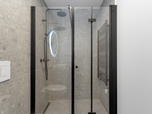Enjoy a tranquil escape in the sleek, modern black shower and furnishings, enhancing the minimalist charm of Hlemmur Suites.