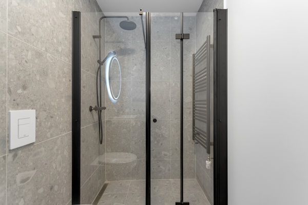 Enjoy a tranquil escape in the sleek, modern black shower and furnishings, enhancing the minimalist charm of Hlemmur Suites.