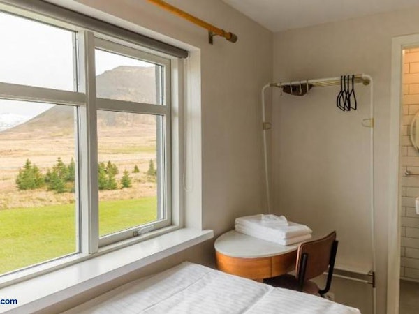 A desk, chair, bed, and breathtaking mountain views from a room at Soti Lodge.