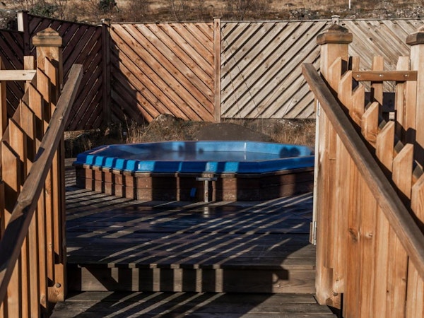 Relax in the outdoor hot tub at Hotel Kvika after a day's exploration.
