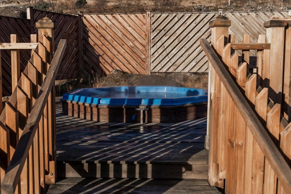 Relax in the outdoor hot tub at Hotel Kvika after a day's exploration.