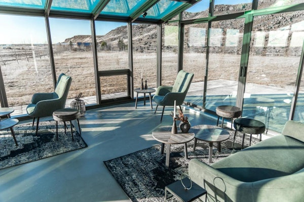 A gorgeous lounge area with huge windows for guests to enjoy the sunshine and countryside vistas at Hotel Kvika.