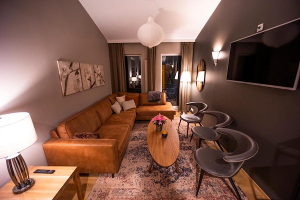A cozy and stylish lounge at Hotel Kvika, with sofas, comfortable chairs, and a table.