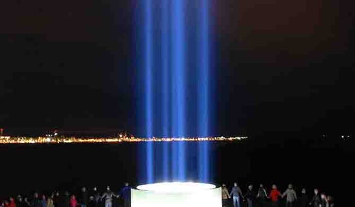 A group bonds at the Imagine Peace Tower over the message of Yoko Ono and John Lennon.
