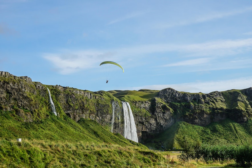 A paraglider over Seljalandsfoss waterfall in South Iceland.
