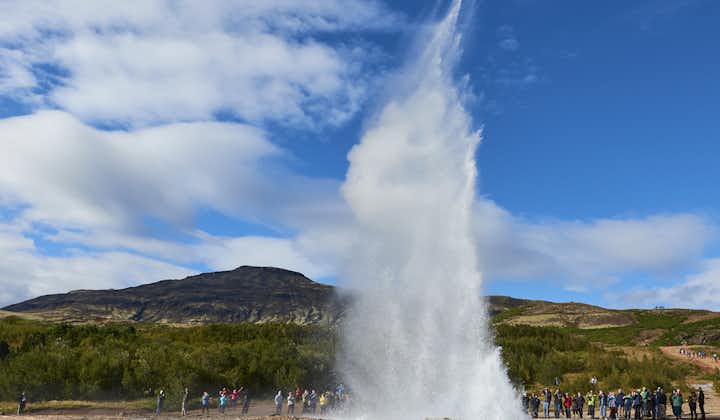 The Strokkur geyser in the Geysir geothermal area erupts, sending hot water high into the air.