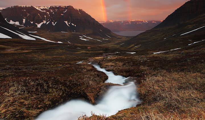Een dubbele regenboog overspant een fjord in de Westfjorden, op een zonnige dag in de IJslandse zomer.
