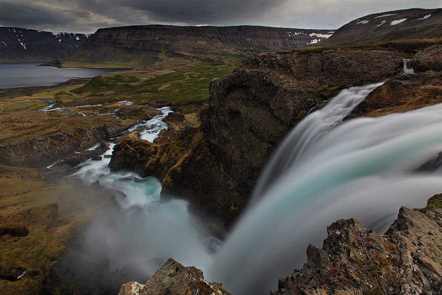 River flows down the mountainside in one of Westfjords beautiful fjords