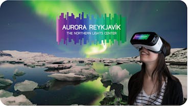 En kvinde som har et VR-headset på mens hun kigger op på Aurora Reykjavik.