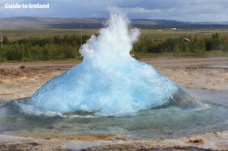 Il geyser Strokkur, blu e ribollente, sul punto di eruttare.