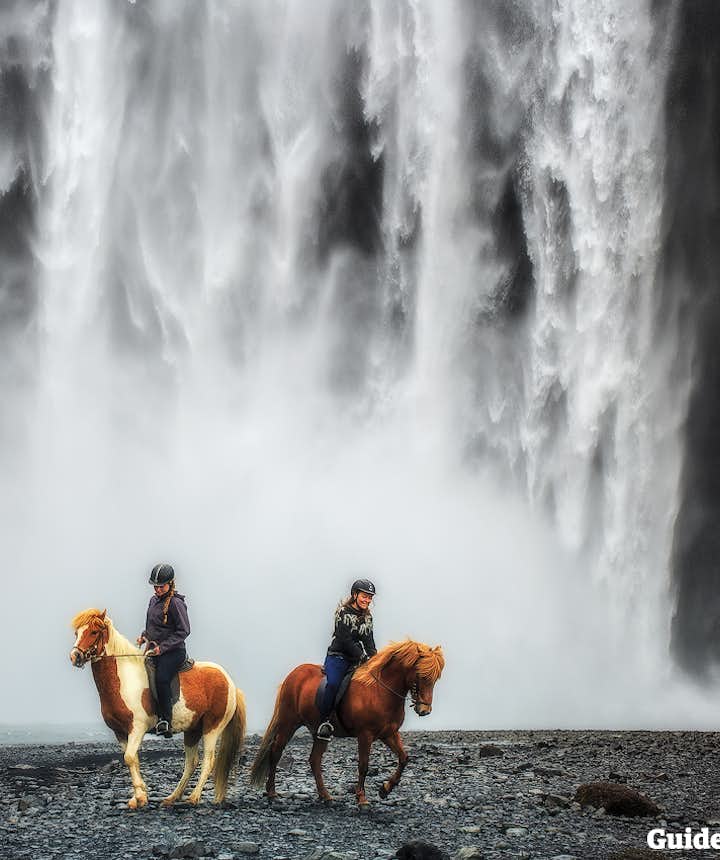 Horseback riding in Iceland, just beside Skógafoss waterfall.