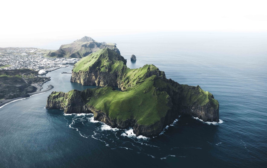 A panoramic view of the islands and houses of the Westman Islands.