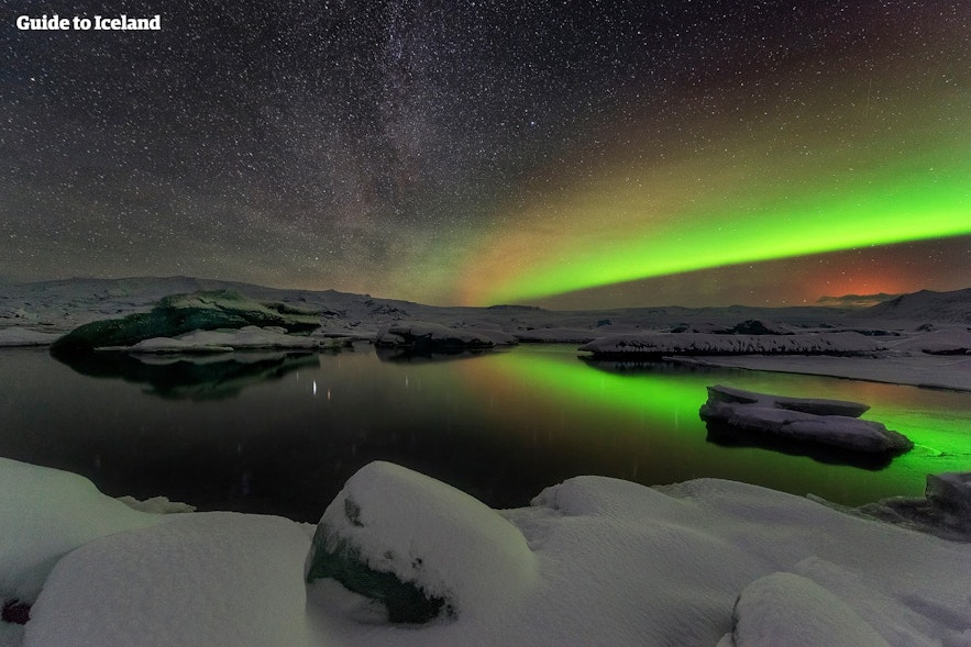 겨울철 아이슬란드의 풍경. 오로라가 얼어붙은 호수 위로 춤을 추고 있습니다.