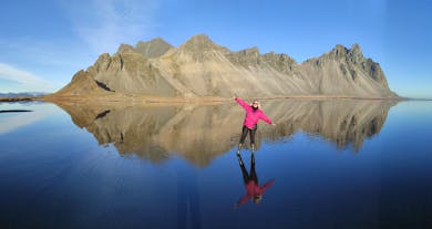 A traveler posing in front of the beautiful Vestrahorn mountain in Iceland.