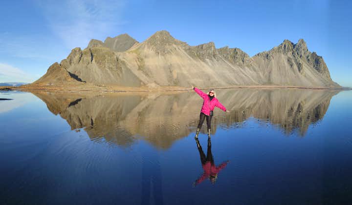 A traveler posing in front of the beautiful Vestrahorn mountain in Iceland.