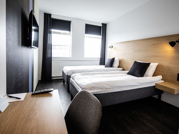 A room with comfortable beds, a desk, and a chair at 201 Hotel in Kopavogur.