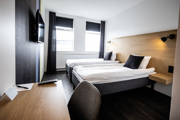 A room with comfortable beds, a desk, and a chair at 201 Hotel in Kopavogur.