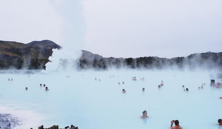 Travelers bathing in the milky-blue waters of the Blue Lagoon.