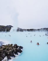 Travelers bathing in the milky-blue waters of the Blue Lagoon.