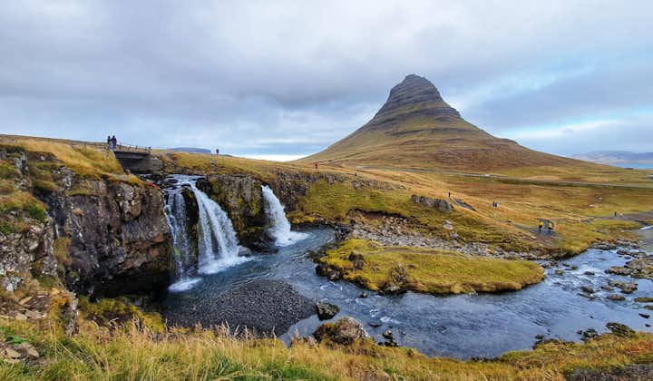 A small waterfall flows in front of the beautiful Kirkjufell mountain in Snaefellsnes.
