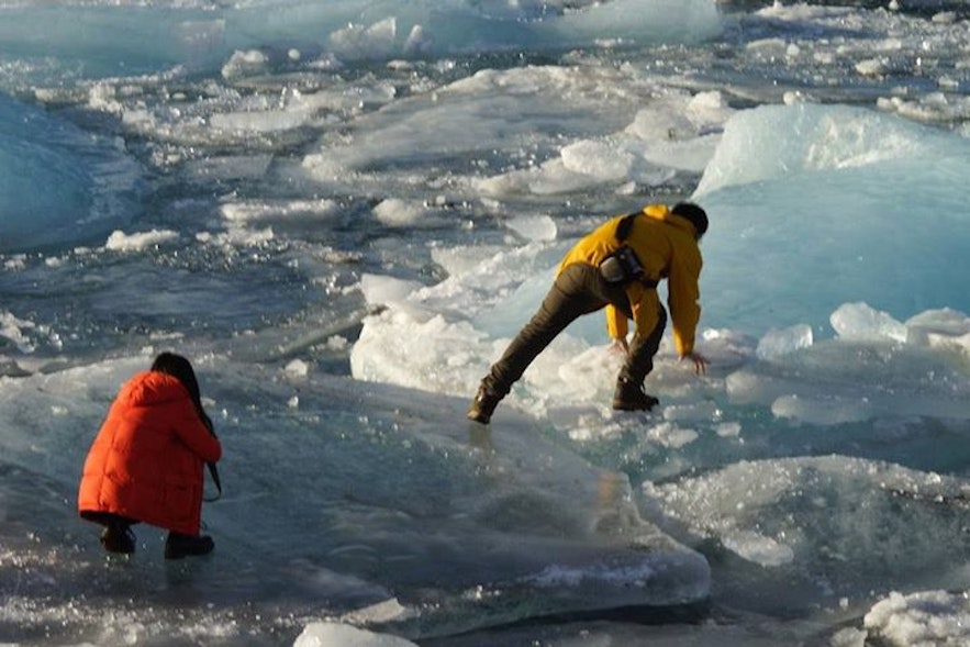 游客在冰岛杰古沙龙冰河湖爬上冰山，危险重重