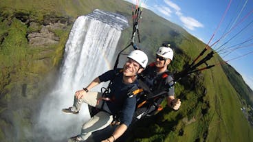 Bei einer Paragliding-Tour an der Südküste fliegst du am mächtigen Wasserfall Skogafoss vorbei.