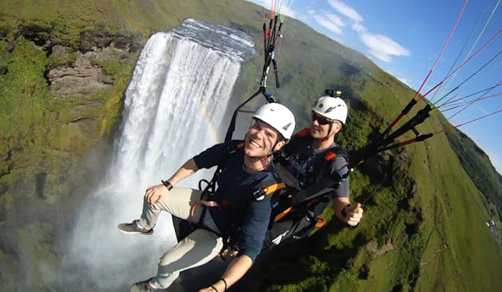 Soaring past the mighty Skógafoss waterfall on a paragliding tour on the South Coast.