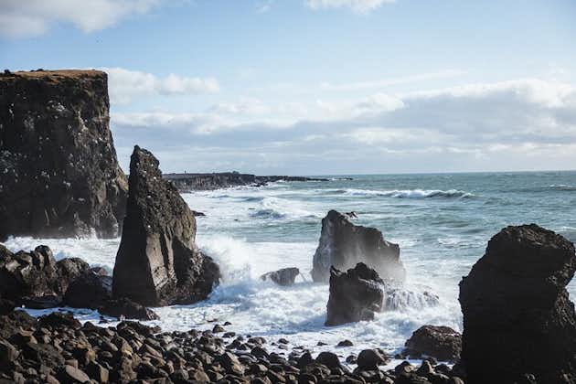 Sea stacks in the Atlantic Ocean off the Icelandic coast as waves come crashing onto the shore.