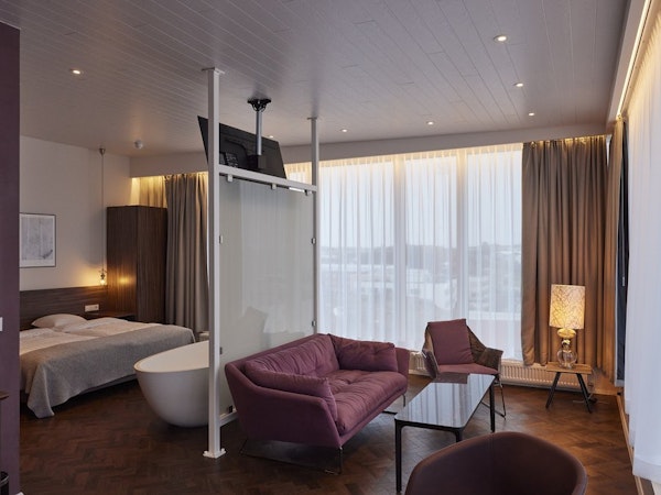 The suites at Hotel Vesturland feature a bathtub in the room's center and a comfortable sitting area.