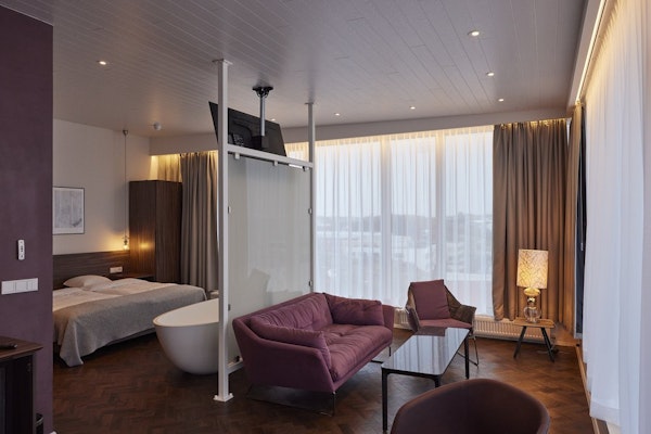 The suites at Hotel Vesturland feature a bathtub in the room's center and a comfortable sitting area.