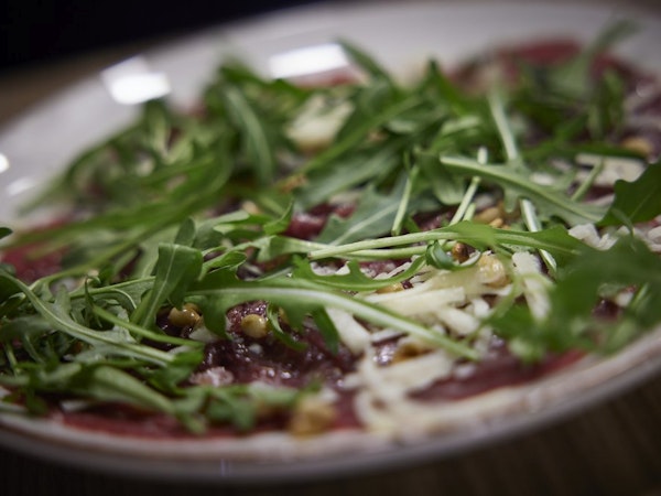 A delicious pizza topped with fresh greens at Hotel Vesturland's restaurant.