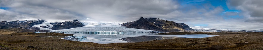A panoramic photo of the Hoffellsjokull glacier's tongue and the mountains surrounding the ice cap.