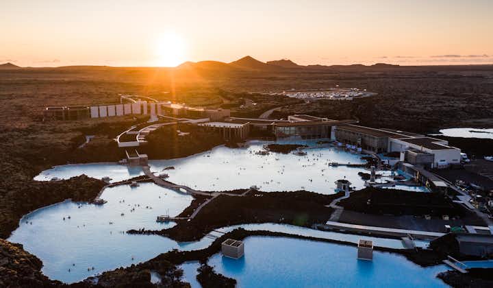 The sun sets behind the Blue Lagoon geothermal spa during autumn in Iceland.
