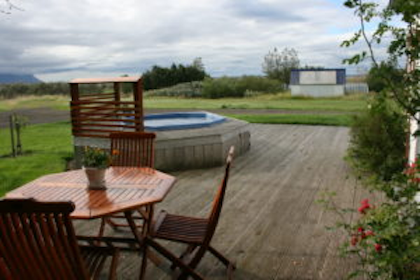 The outside area at Jadar Farm with a wooden table and a hot tub.