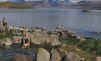 Guests enjoying a geothermal bath at Hvammsvik hot springs in West Iceland.