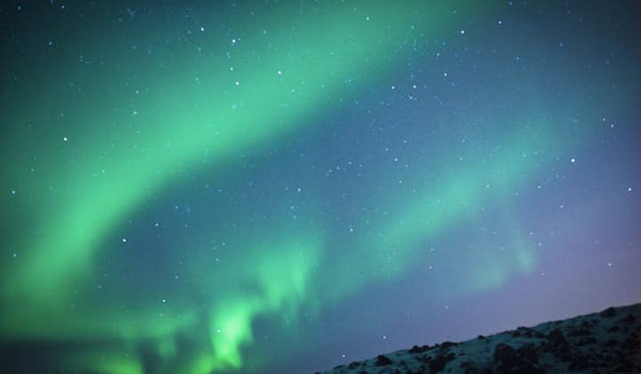 An ethereal sky of infinite stars and descending aurora lights in west Iceland's winter.