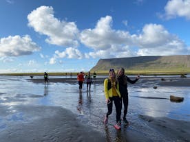 People on a running tour pose for a photo as they wade through a shallow river in the Westfjords.
