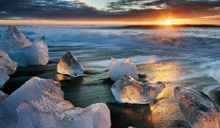 Il sole di mezzanotte splende sulla Spiaggia dei Diamanti nella costa meridionale islandese.