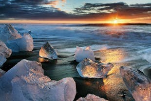 Le soleil de minuit éclaire de sa magnifique lumière la plage de diamants dans le sud de l'Islande.