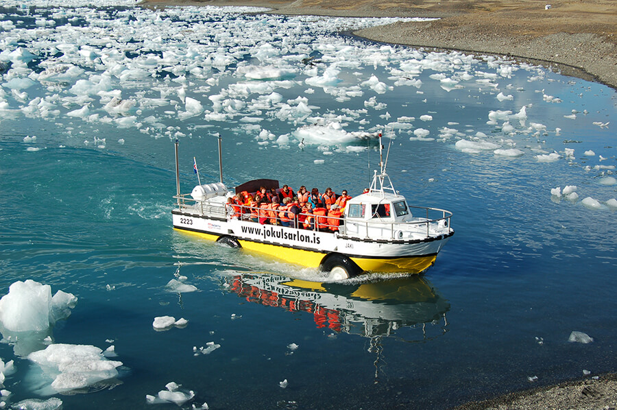 An amphibious boat cruises across the Jökulsárlón glacier lagoon.