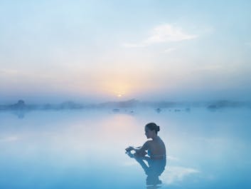 A woman relaxes in the healing waters of the Blue Lagoon geothermal spa.
