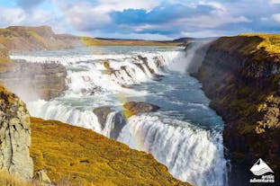 Gullfoss waterfall, one of Iceland's three Golden Circle attractions, looks spectacular with a rainbow in front on a sunny day.