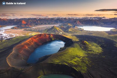 Ljotipollur has striking blue water and reddish-brown crater walls surrounding it amid the otherworldly mountainous landscapes of the Icelandic Highlands.