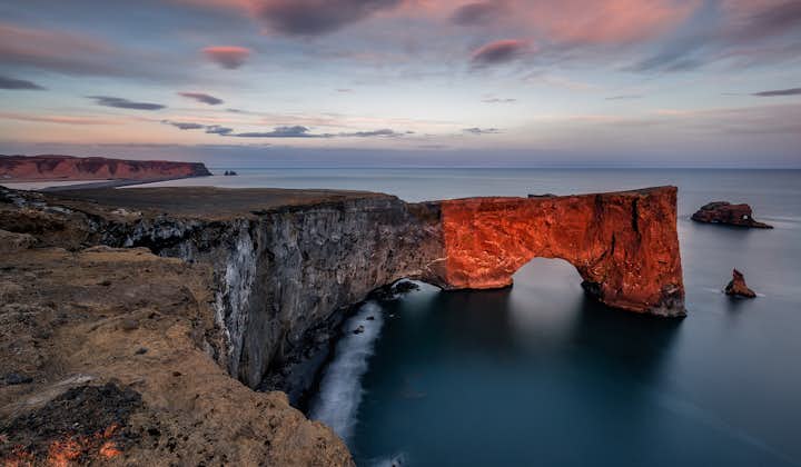 Dyrhólaey is een enorme rotsboog die zich vanaf de Zuid-IJslandse kust uitstrekt de zee in.