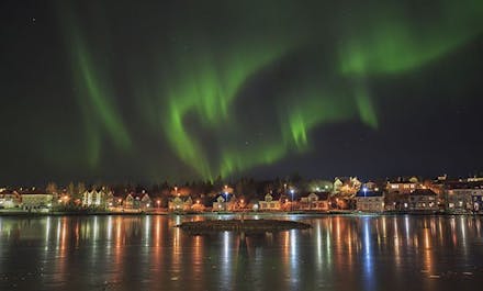The cityscape of Reykjavík beneath the aurora borealis.