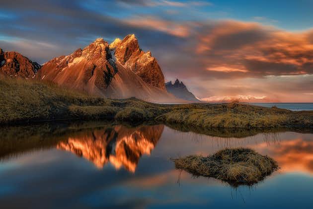 The rugged peaks of Vestrahorn Mountain in East Iceland, bathed by the rays of the midnight sun.
