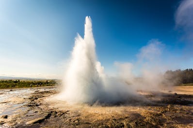 Le geyser Strokkur, situé sur l'itinéraire touristique du Cercle d’Or, avec de l'eau bouillante jaillissant du sol.
