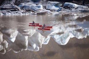 An overhead view of people kayaking on the Solheimajokull glacier lagoon on Iceland's South Coast.