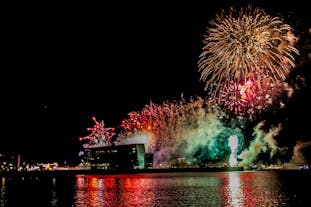 Fireworks during New Year's in Iceland casting their lights on Harpa Concert Hall.