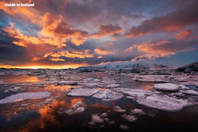 夏季的神奇午夜阳光倒映在冰岛东南岸的杰古沙龙冰河湖中。